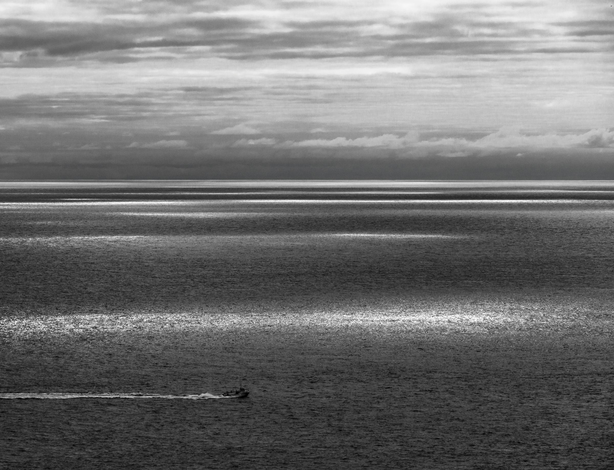 Einsames Boot auf dem Nordatlantik, Lichtstreifen auf dem offenen Meer, Minimalistische Weite - Island Seestück