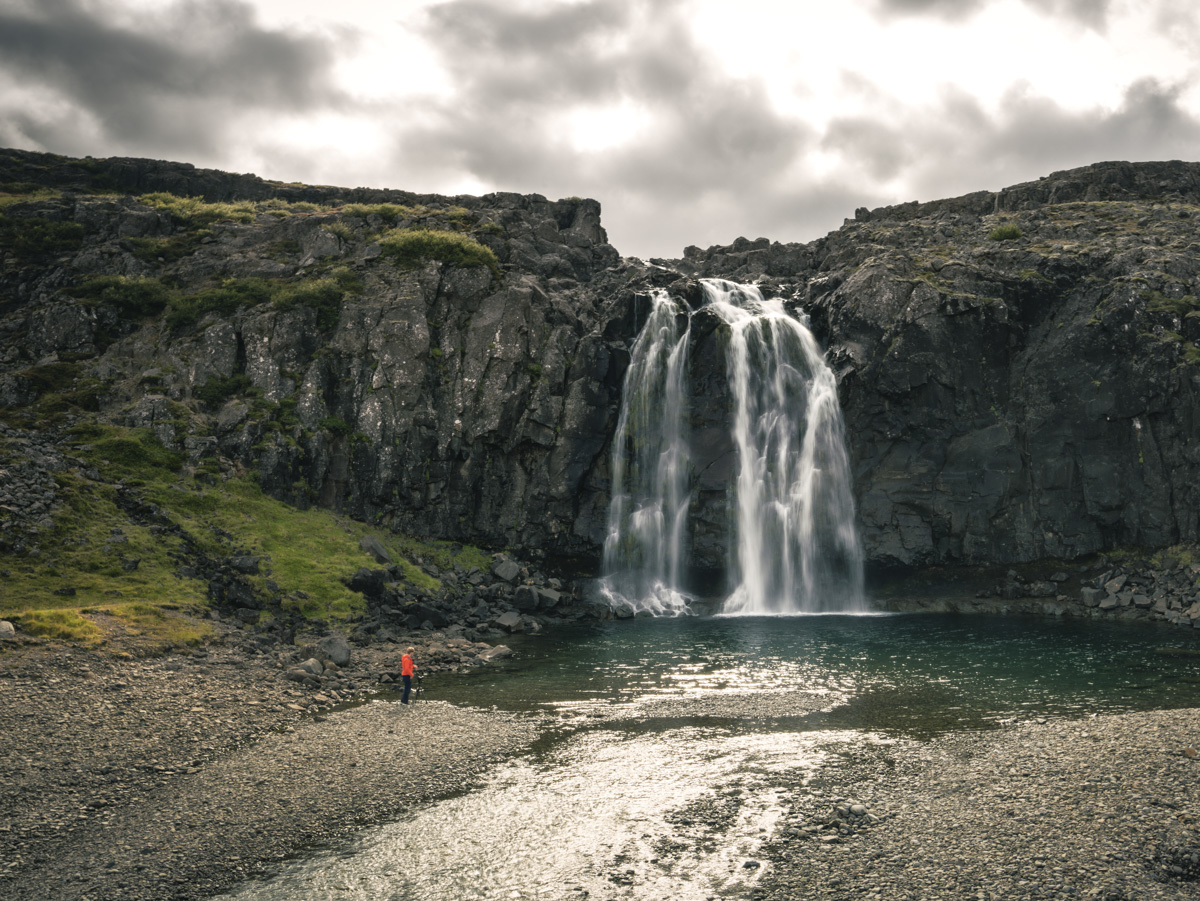 Isländischer Wasserfall, Wanderer vor stürzenden Wassermassen in Felsenkessel, Abenteuer und Wildnis - Island Reisefotografie