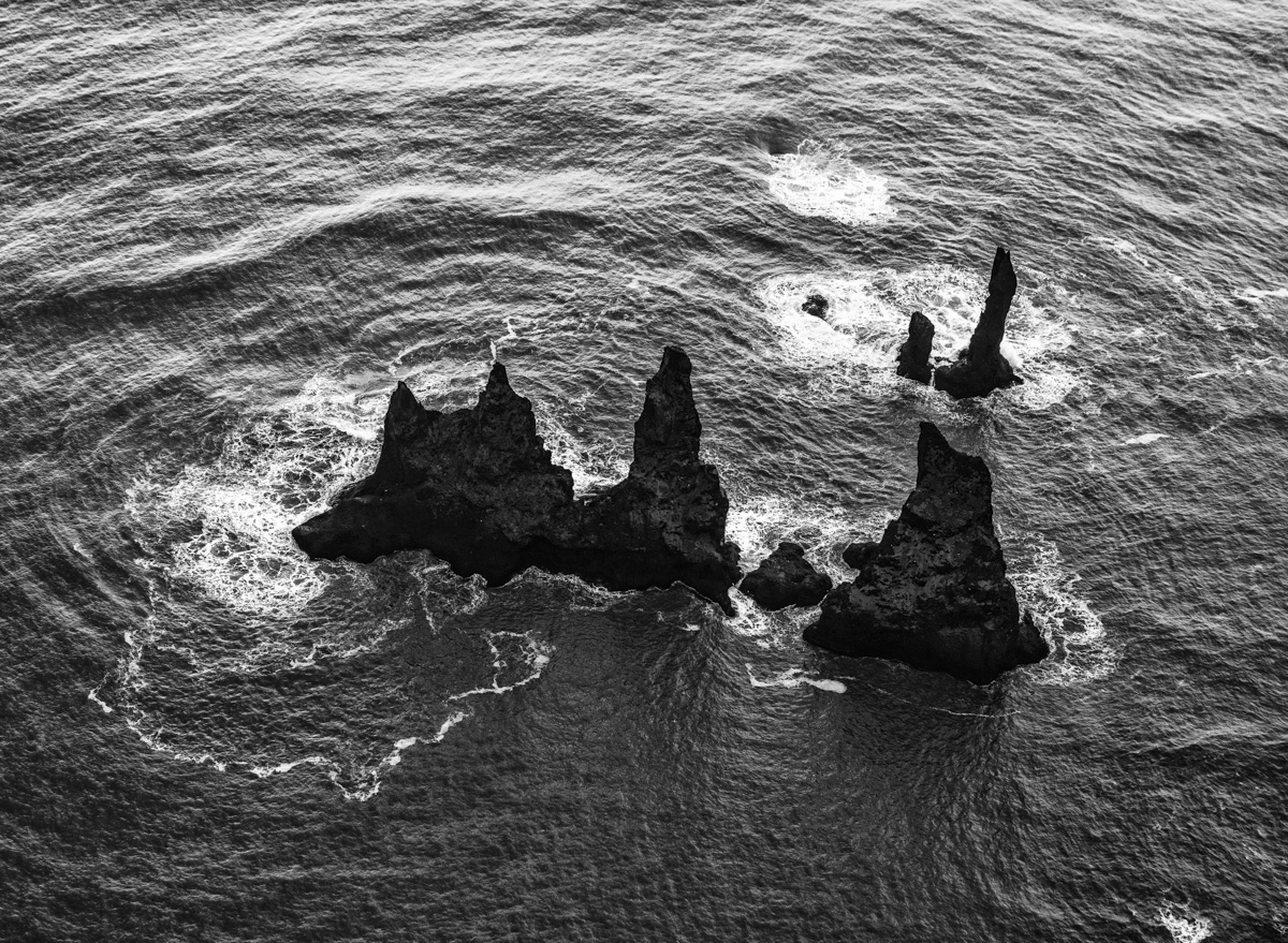 Reynisdrangar von oben, Isländische Felsnadeln im tosenden Meer, Schwarz-Weiß - Küstenfotografie Island