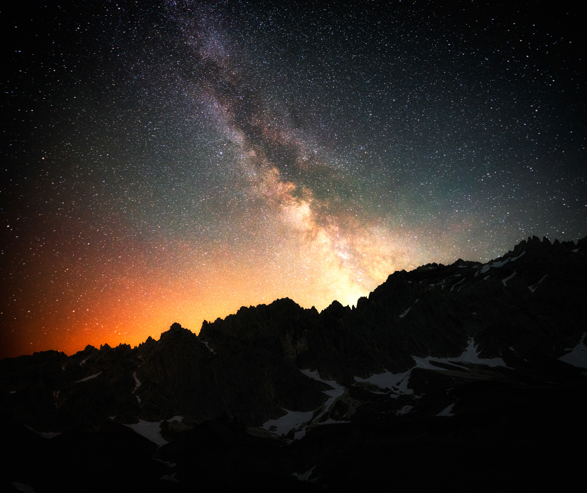 Milchstraße mit Sternschnuppe über Hinterstein, Sommernacht im Allgäu, Orange Lichtsaum hinter den Bergen