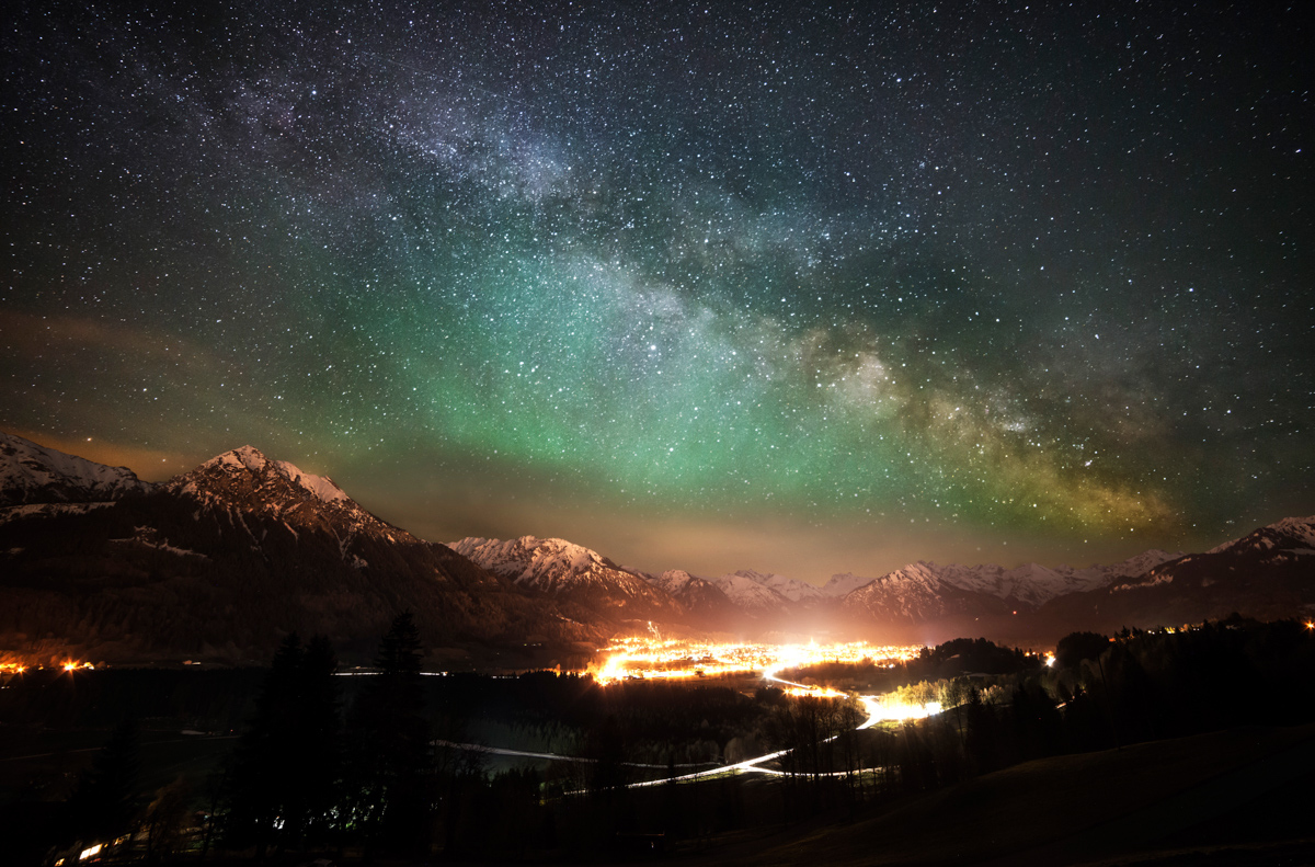 Milchstraße über Oberstdorf, Grüner Airglow und beleuchtetes Alpental im Frühling, Faszinierende Nachtstimmung