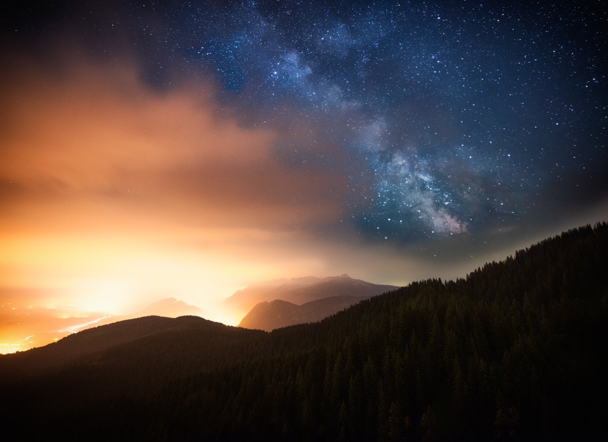 Milchstraße über Nadelwald, Warmes Horizontleuchten und Bergsilhouetten in Sommernacht, Kontrastreiche Nachtlandschaft