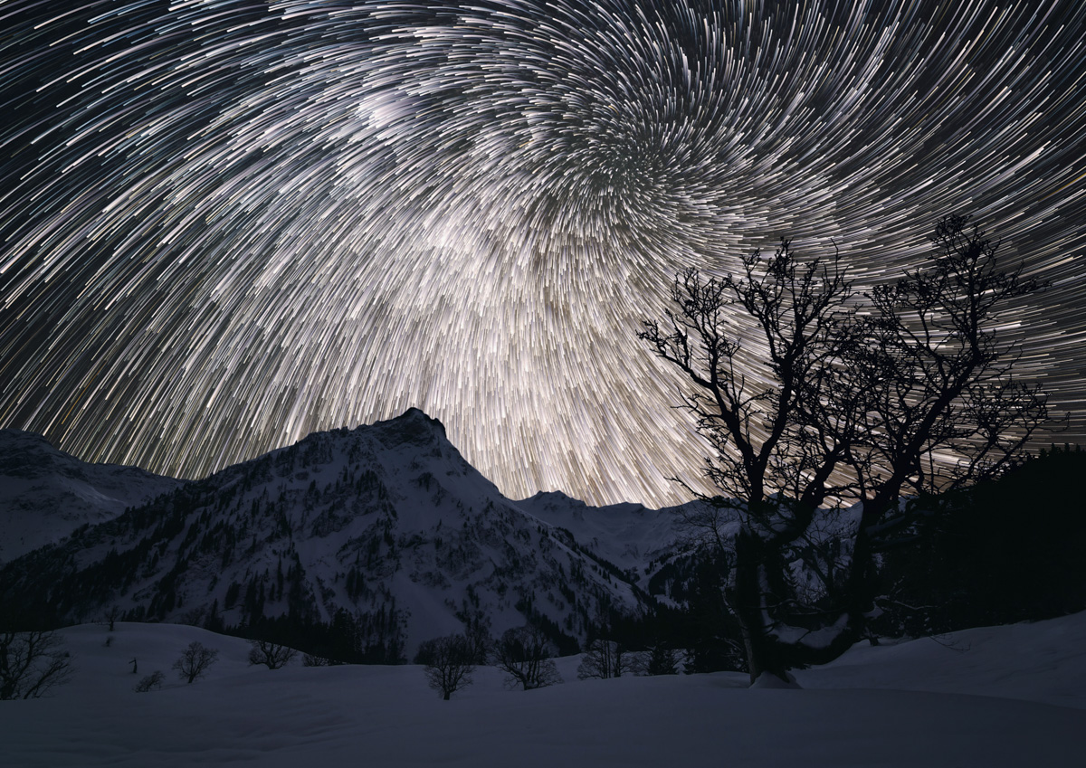 Hinterstein, Sternspuren über verschneitem Giebel und Hochvogel, Winternacht - Astrofotografie Allgäu
