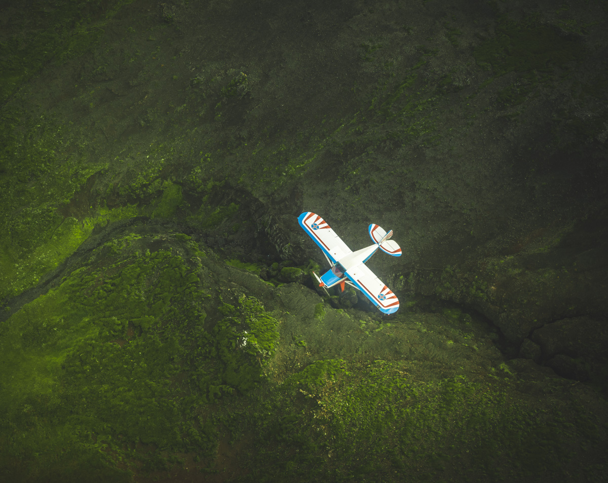 Flugzeug über Island, Doppeldecker über grüner Vulkanschlucht von oben, Abenteuer - Luftbildfotografie Island