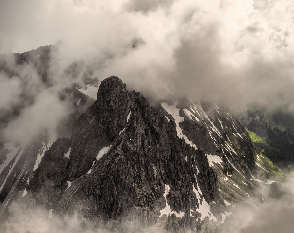Ifen Kleinwalsertal, Dramatischer Berggipfel mit Gipfelkreuz in Wolken, Bergstimmung - Bergfotografie Vorarlberg