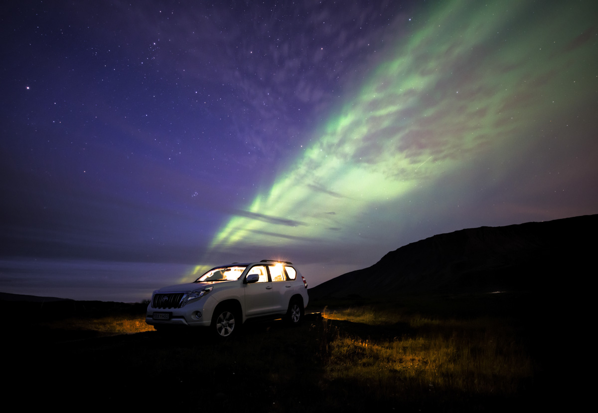 Nordlichter Island, Aurora Borealis über Geländewagen im Hochland, Nacht - Astrofotografie Island