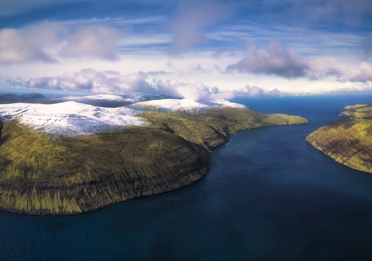 Färöer Fjord, Tiefer Meeresarm zwischen schneebedeckten grünen Inseln aus der Luft, Arktische Landschaft - Drohnenfotografie