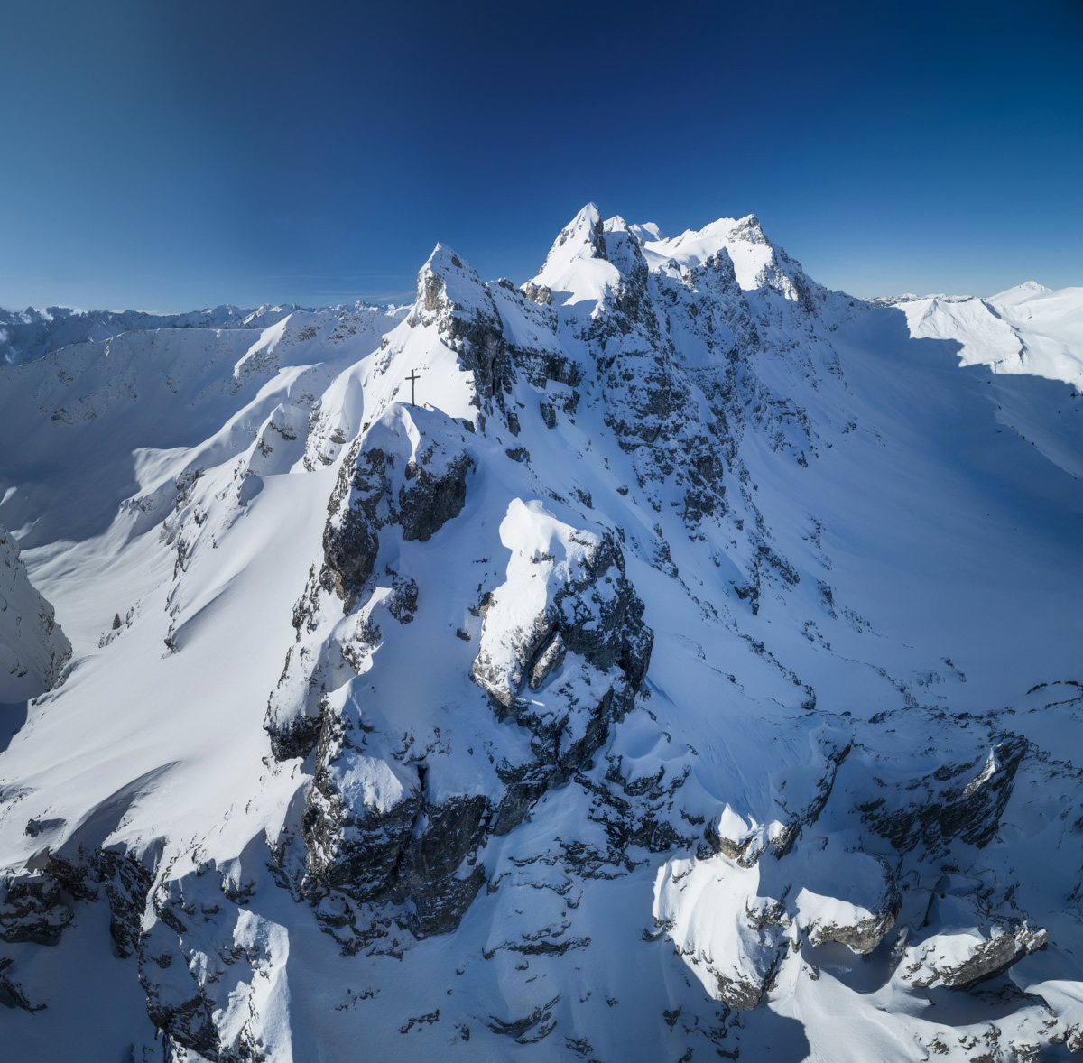 Kleiner Daumen, Gipfelkreuz über verschneiten Felswänden, Winterliche Hochalpenlandschaft - Bergfotografie Allgäu