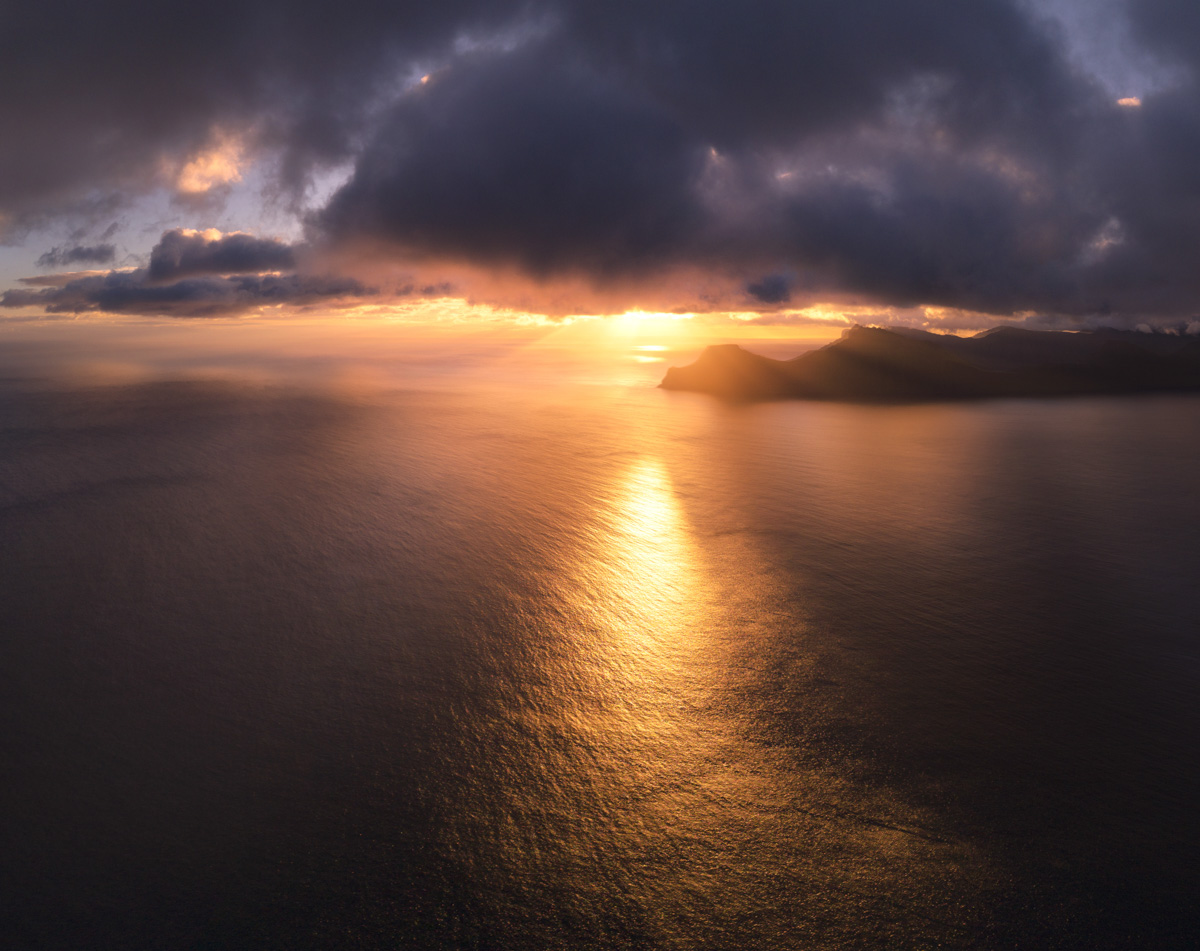 Färöer Sonnenuntergang über dem Meer, Goldene Lichtreflexion auf dem Nordatlantik mit Inselsilhouette, Goldene Stunde