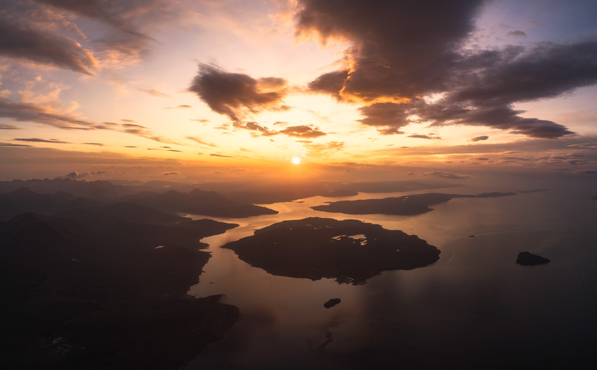 Mitternachtssonne über schottischen Inseln, Warmes Abendlicht über Fjorden, Dramatische Wolken und stilles Meer