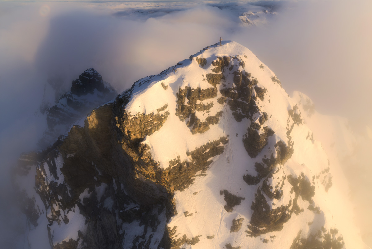 Gipfelkreuz über den Wolken, Verschneiter Berggipfel bei Hinterstein im Winterlicht, Erhabene Gipfelwelt - Bergfotografie