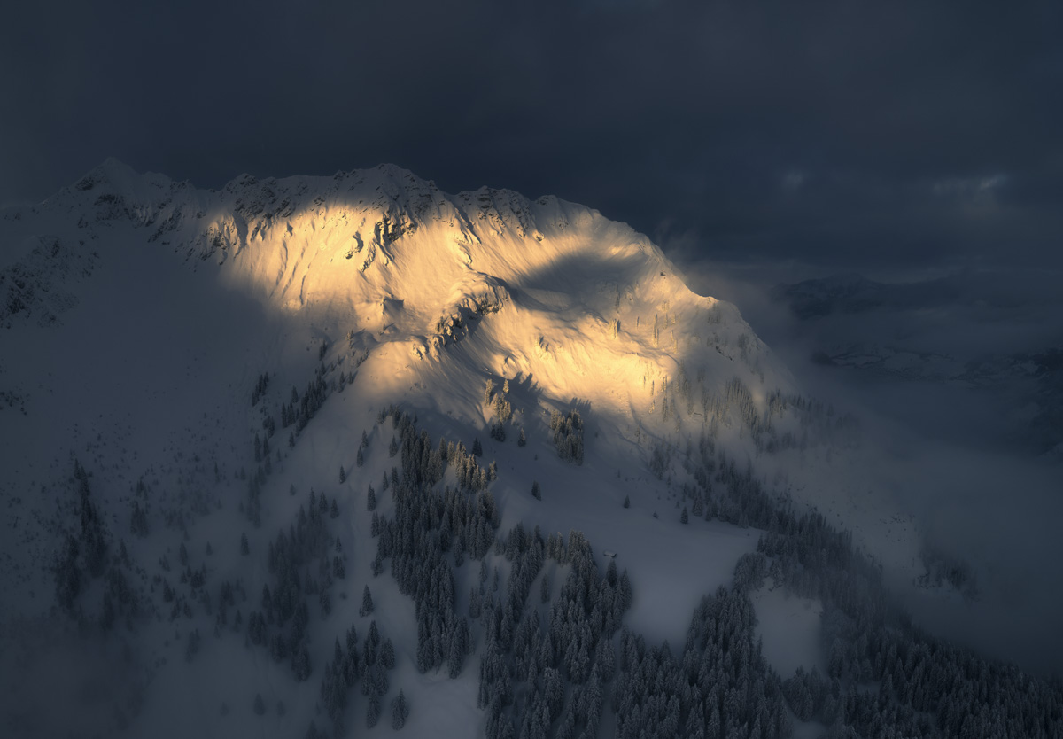 Breitenberg im goldenen Lichtstrahl, Winterlicher Sonnenaufgang durch Wolken bei Hinterstein, Dramatisches Bergporträt