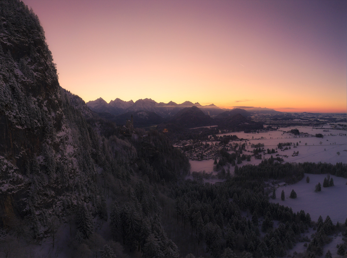 Schloss Neuschwanstein, Winterliches Märchenschloss mit Alpenpanorama bei Sonnenuntergang, Alpenglühen