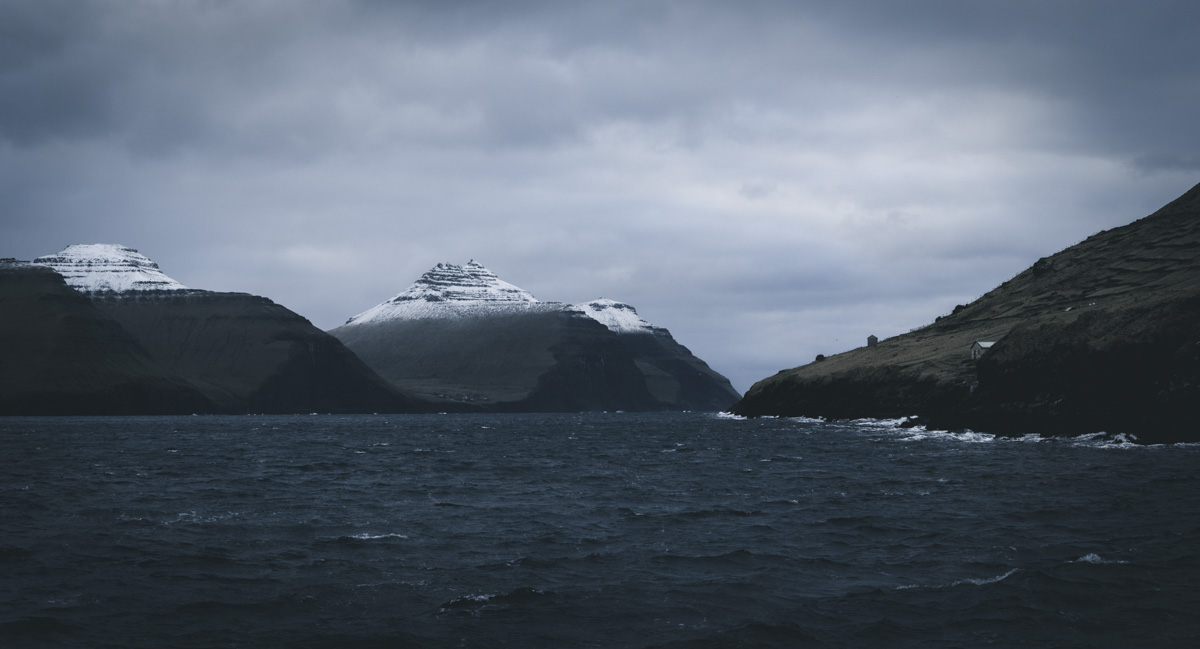 Färöer Fjord, Schneebedeckte Bergpyramiden über dunklem Fjord, Winterstimmung - Landschaftsfotografie Nordatlantik