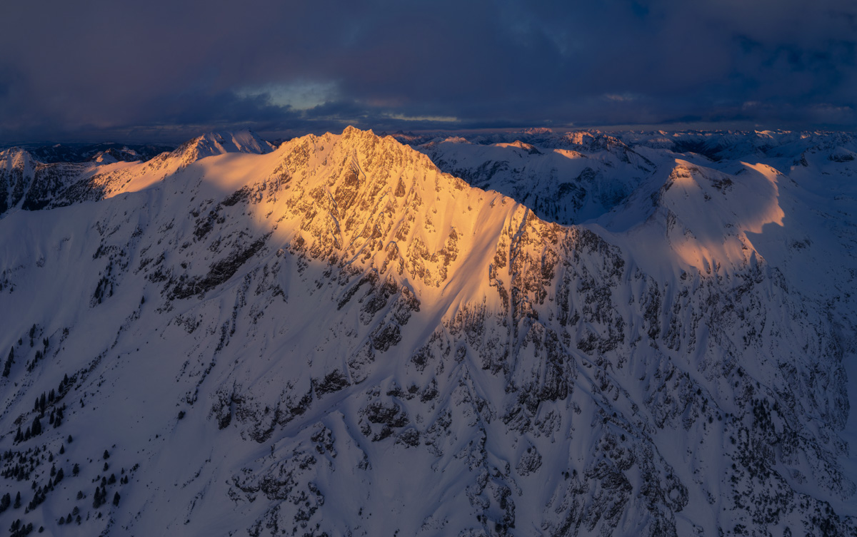 Hinterstein, Alpenglühen auf verschneiter Bergflanke unter dramatischem Wolkenhimmel, Winterlicht - Bergfotografie Allgäu
