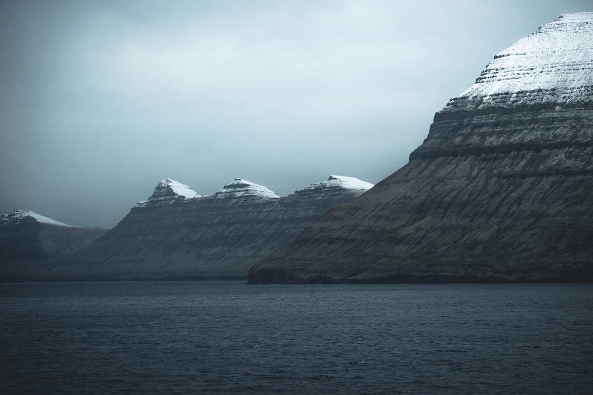 Färöer Berge, Verschneite Schichtberge vom Fjord aus gesehen, Winterstille - Landschaftsfotografie Nordatlantik