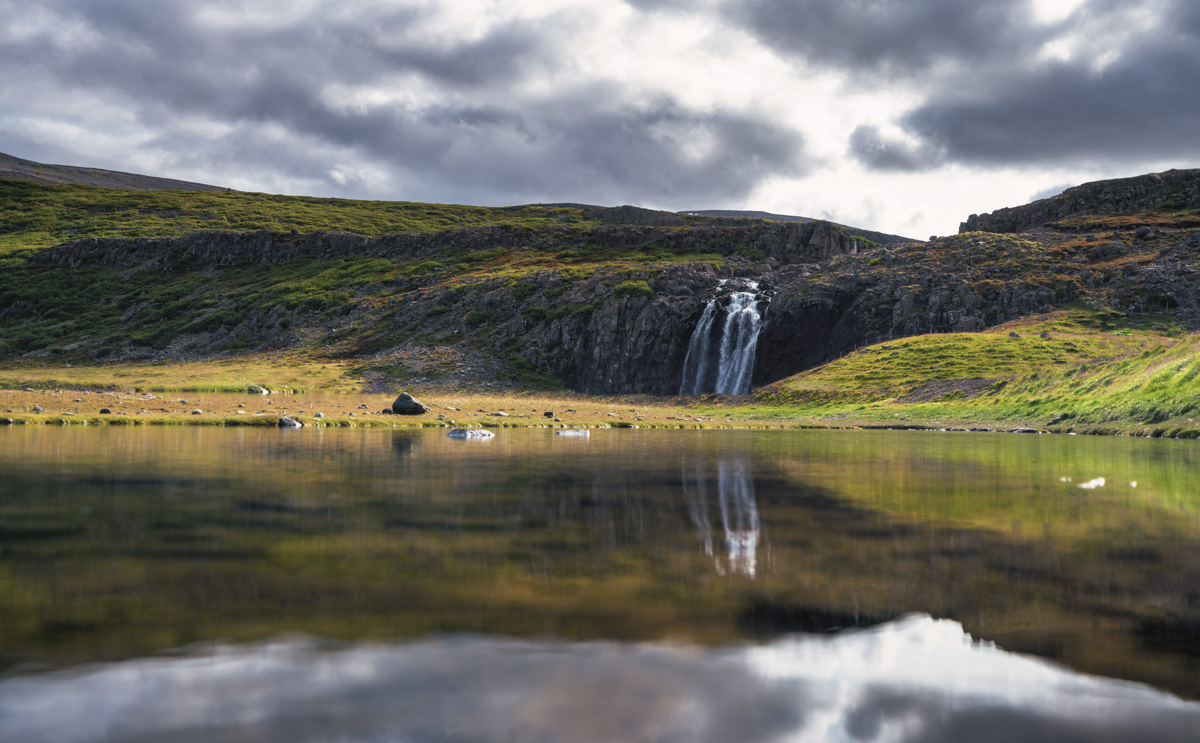 Wasserfall am Bergsee, Stille Spiegelung unter dramatischen Wolken, Atmosphärisch - Landschaftsfotografie Island