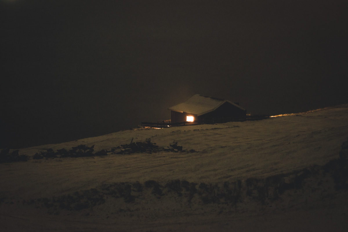 Färöer Winternacht, Einsames beleuchtetes Haus auf verschneitem Hügel, Stille Nacht - Nachtfotografie Nordatlantik