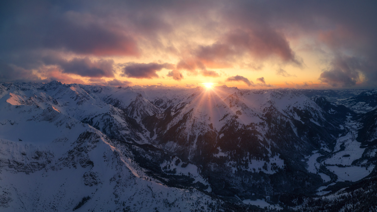 Hinterstein, Sonnenstern über dem verschneiten Hochvogel im Winter, Dramatische Winterstimmung - Bergfotografie Allgäu