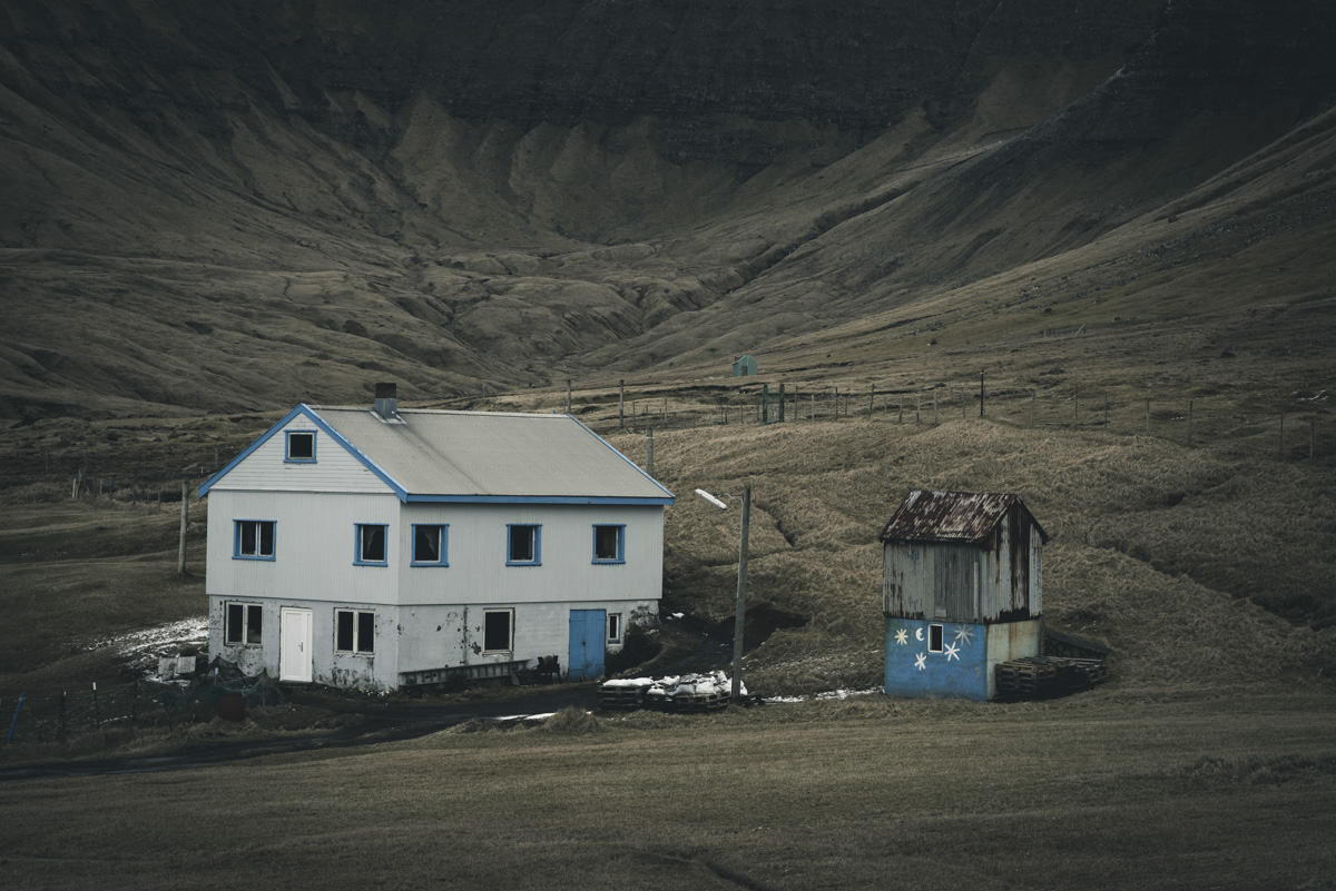 Färöer Bauernhaus, Einsames Haus mit Nebengebäude vor dunklem Berghang, Ländliche Stille - Architekturfotografie Nordatlantik