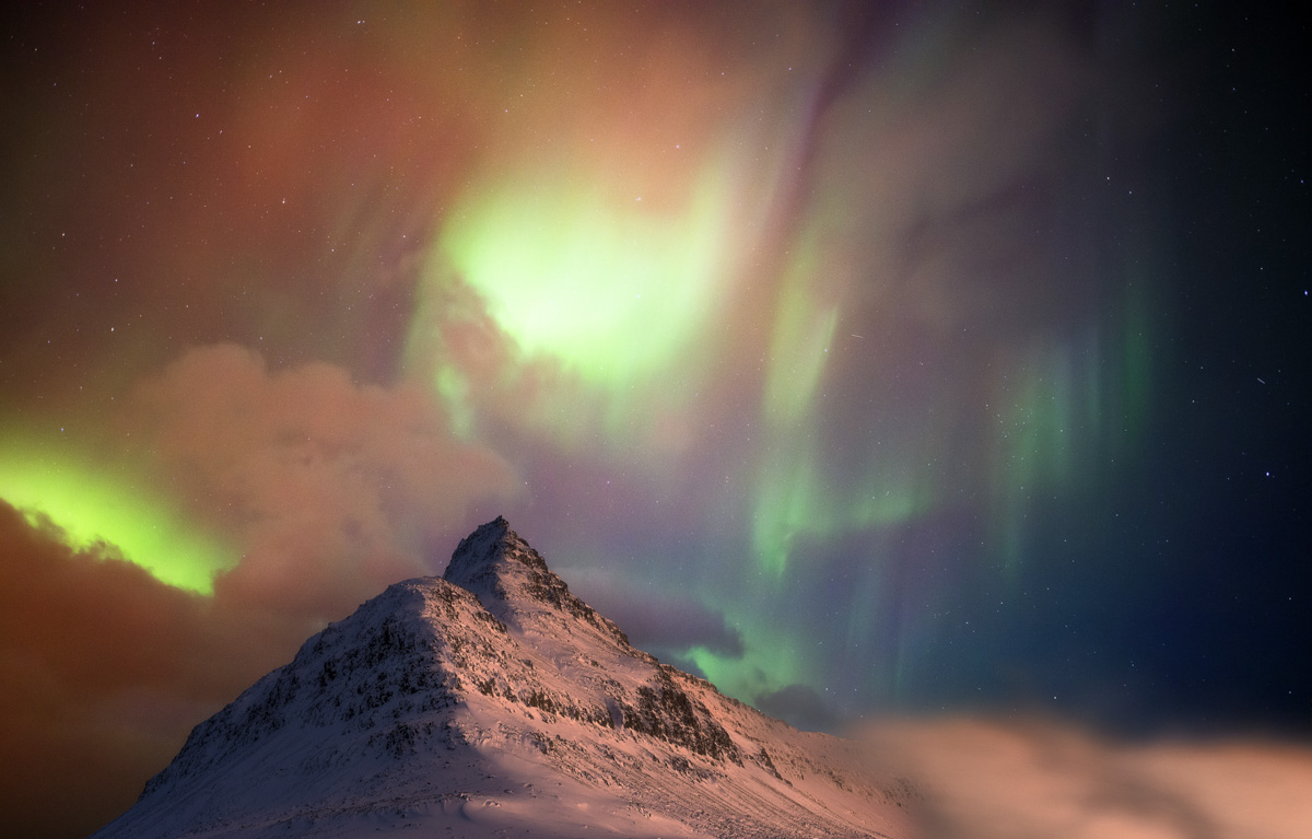 Nordlichter über dem Berggipfel, Aurora Borealis in Grün und Orange über Schneebergen, Magisch - Nachtfotografie Island