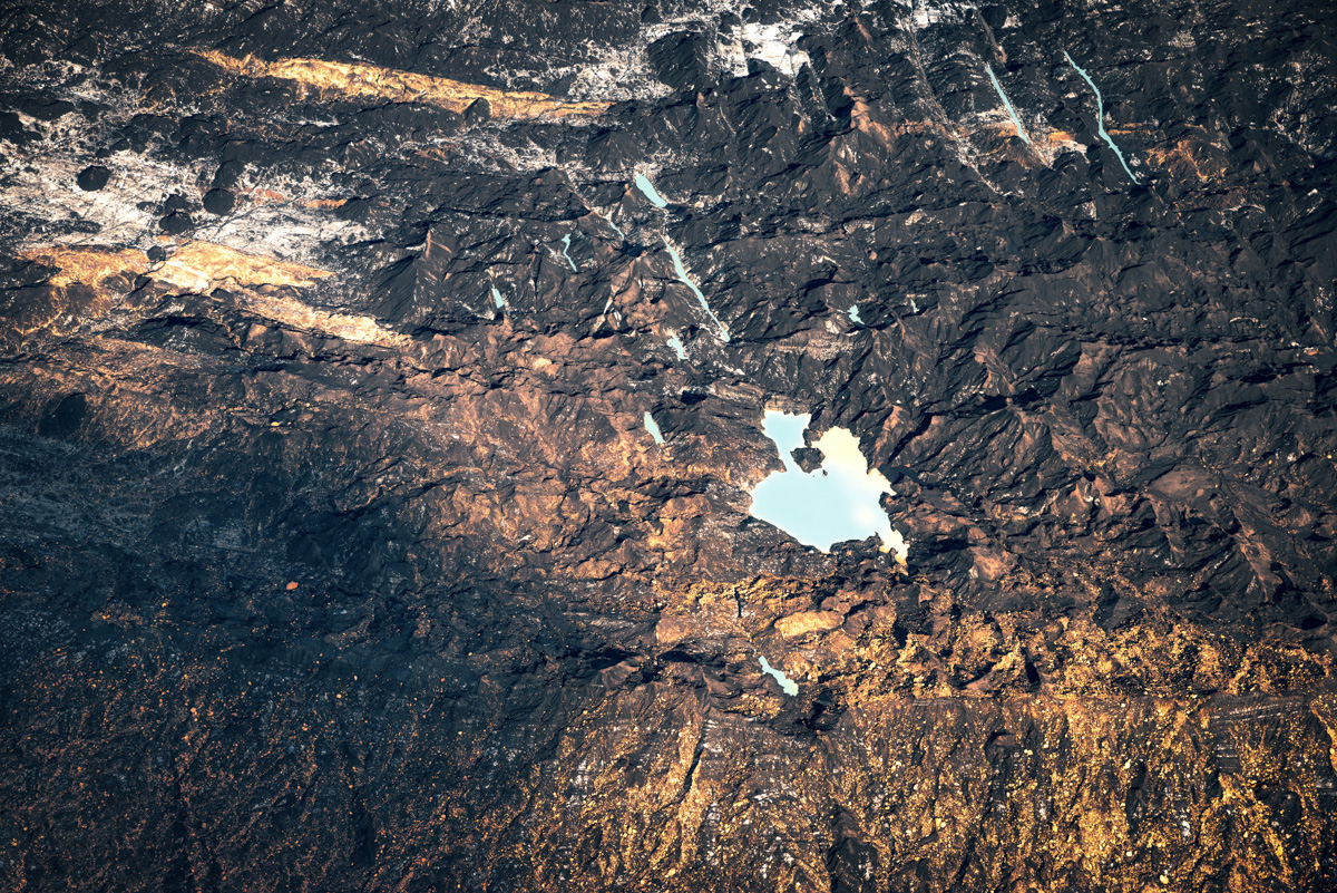 Türkiser Vulkansee im Lavafeld, Goldenes Licht auf dunklem Gestein, Abstrakte Luftaufnahme Island