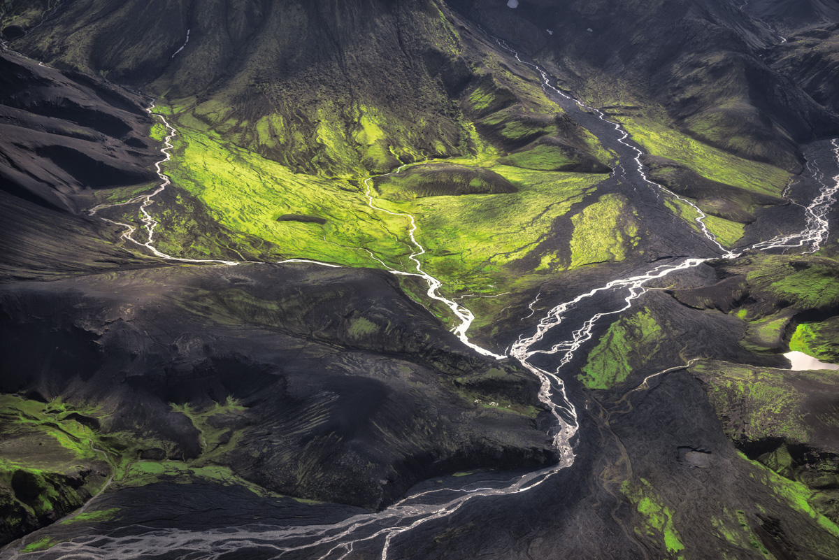 Abstrakte Hochlandflüsse und Moosfelder von oben, Schwarz-grüne Vulkanlandschaft, Aerial Island Kunst