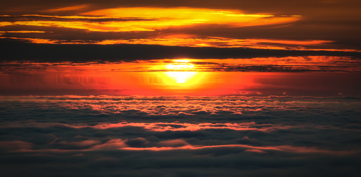 Sonnenuntergang über dem Wolkenmeer Island, Glühende Sonne über Wolkendecke, Epischer Himmel Hochland
