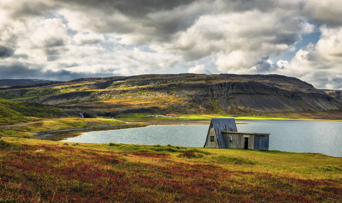 Verlassene Holzhütte am Fjord Fossfjörður, Westfjorde Herbstlandschaft Island, Wasserfall und Berge