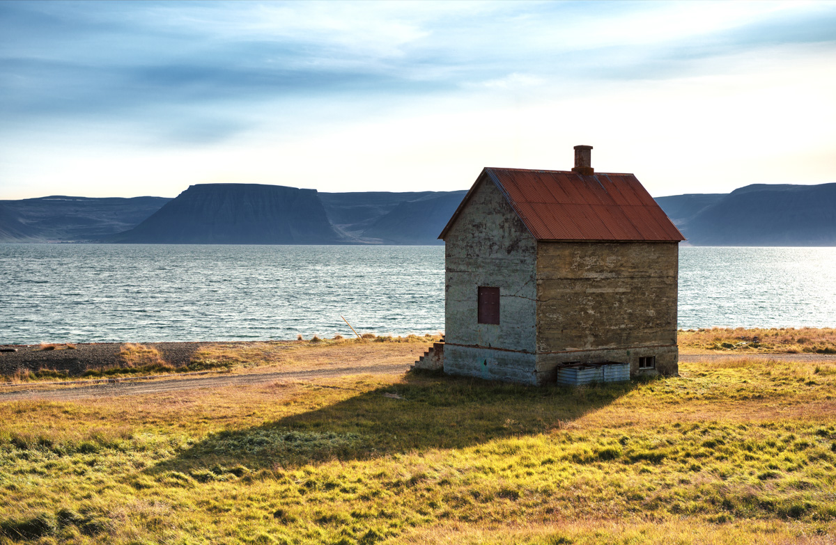Verlassenes Haus am Fjord Westfjorde, Rostiges Dach und Tafelberge Island, Goldenes Abendlicht Küste