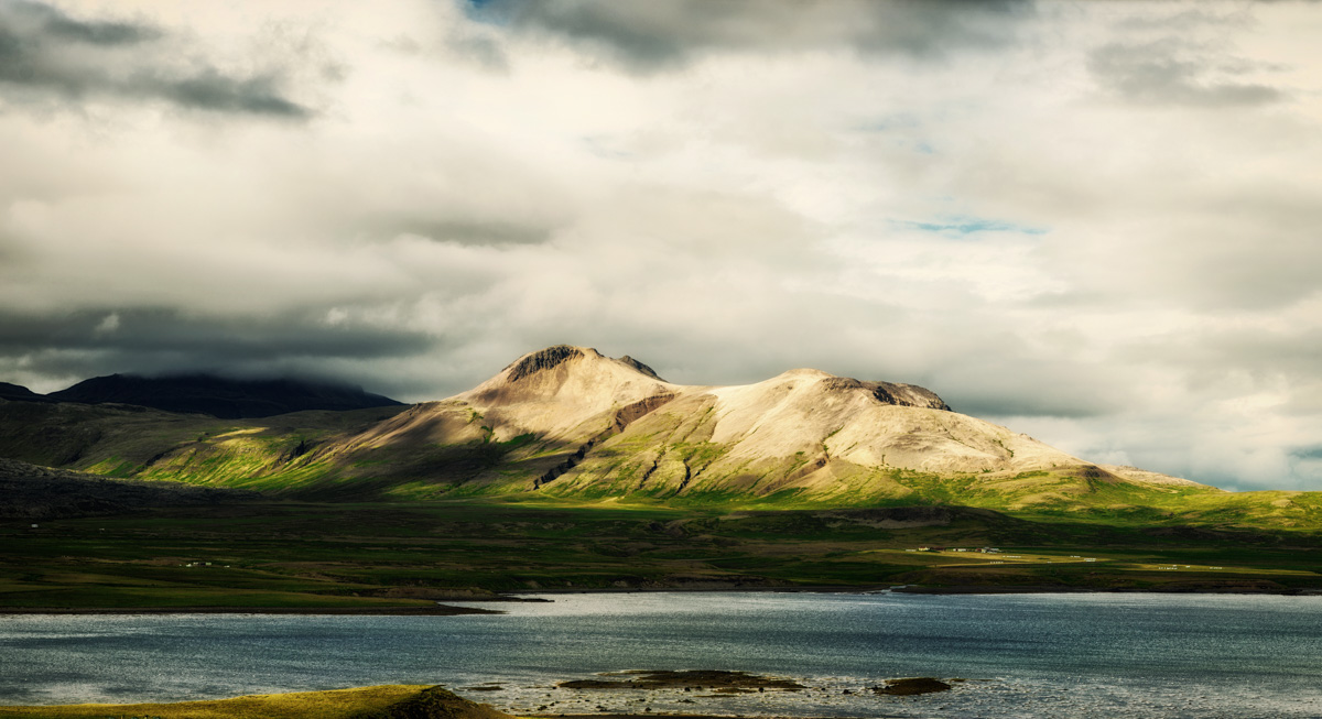 Helle Rhyolith-Berge am Fjord, Sonnenlicht auf Vulkangestein Island, Dramatische Wolken Westisland