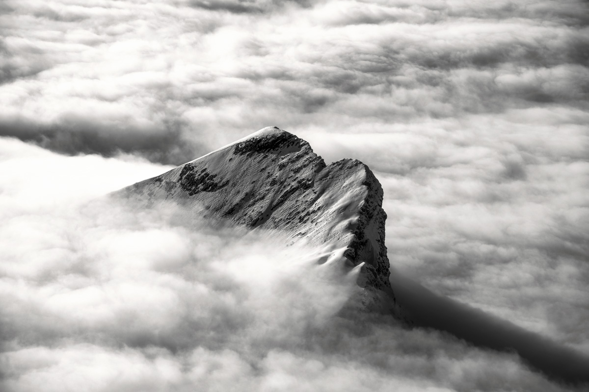 Kurfürsten, Verschneiter Berggipfel ragt aus dem Nebelmeer in Schwarz-Weiß, Zeitlose Bergmajestät - Kunstfotografie Schweiz