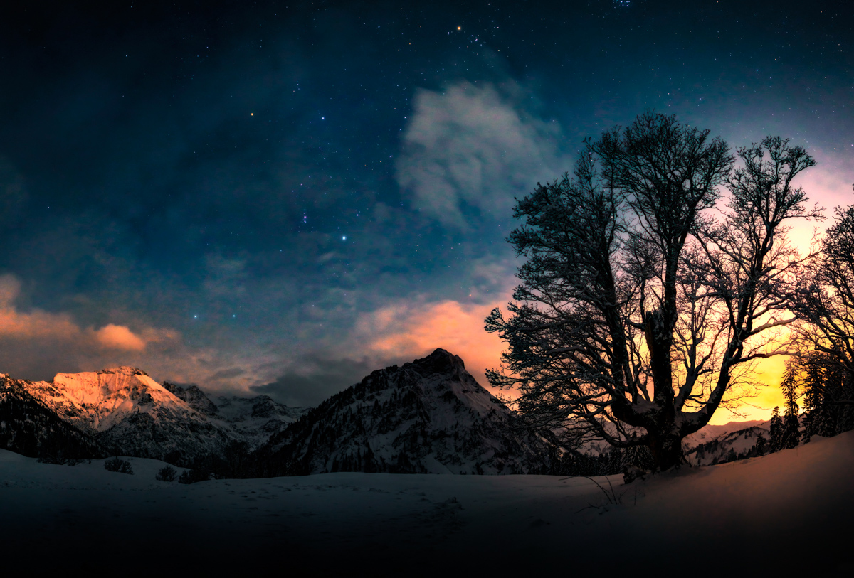 Sternenhimmel über Hinterstein und Schwarzenberg, Kahler Baum vor verschneiten Bergen mit leuchtenden Wolken, Dramatische