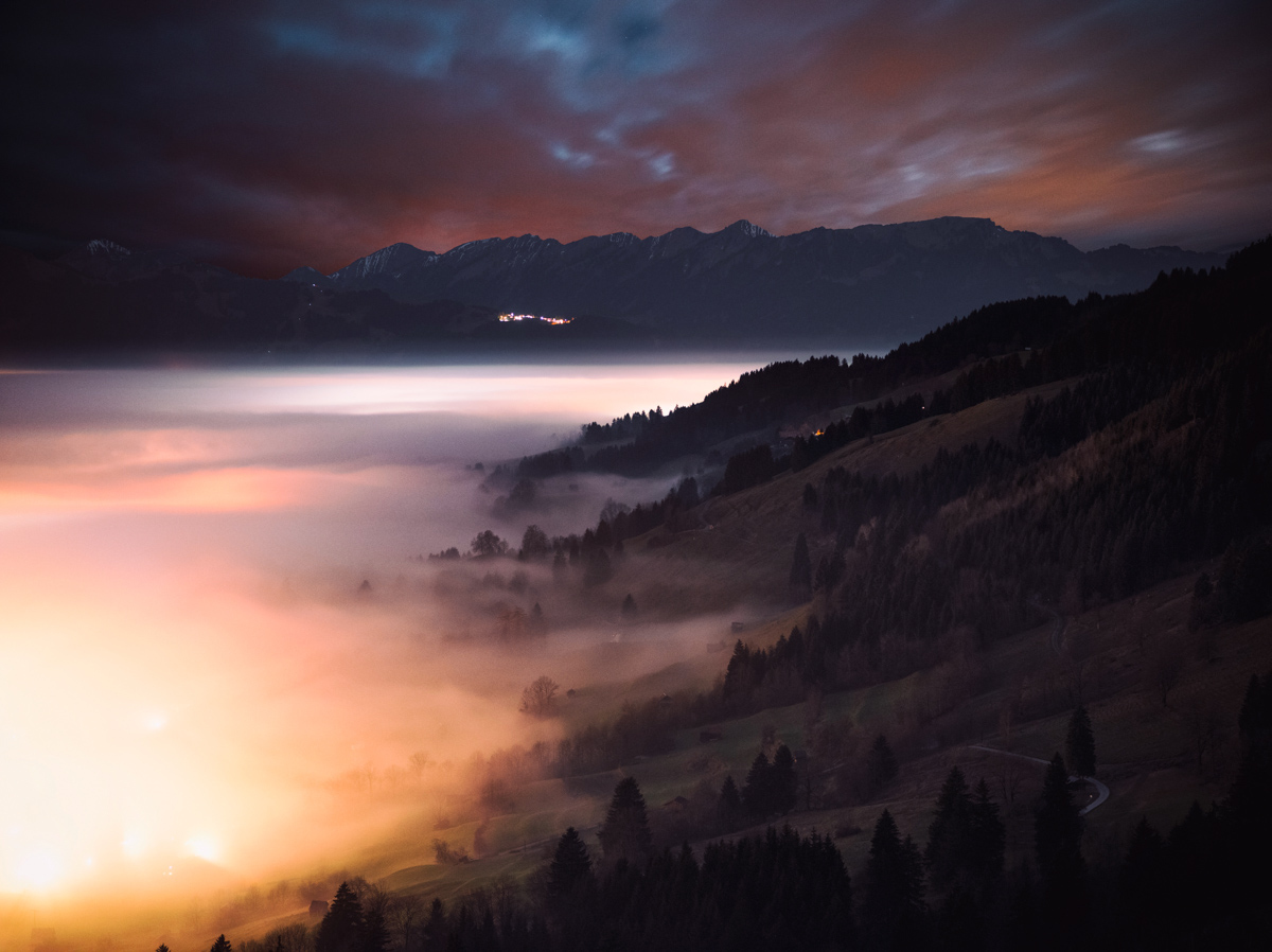 Nebelmeer über Hindelang bei Nacht, Leuchtende Nebelwellen im Allgäuer Tal mit Bergsilhouetten, Mystische Sommernacht