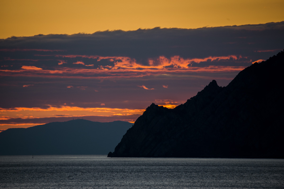 Ligurische Küste bei Sonnenuntergang, Bergsilhouette vor orangem Himmel, Dramatisches Abendrot am Mittelmeer