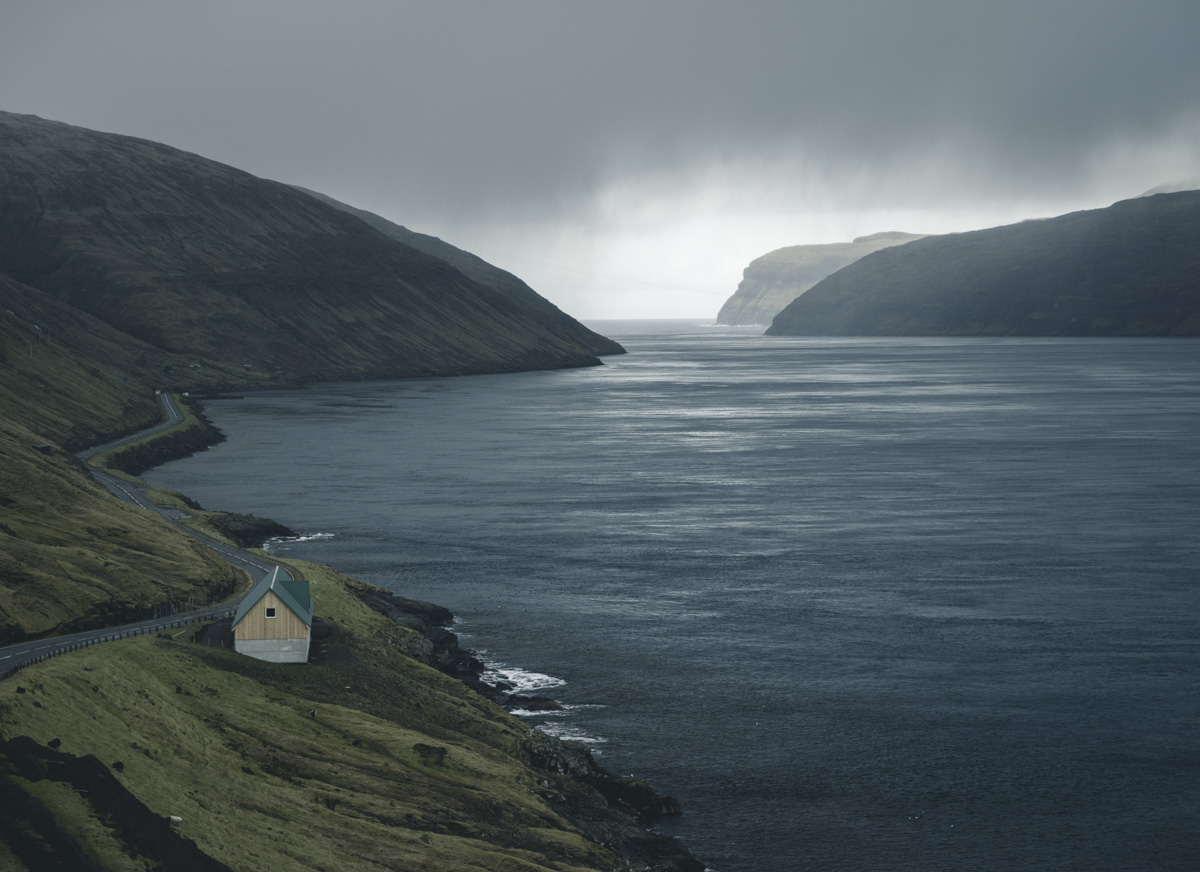 Färöer Inseln, Einsames Haus am Fjord mit herannahendem Regenschauer, Nordatlantische Küstenidylle - Landschaftsfotografie