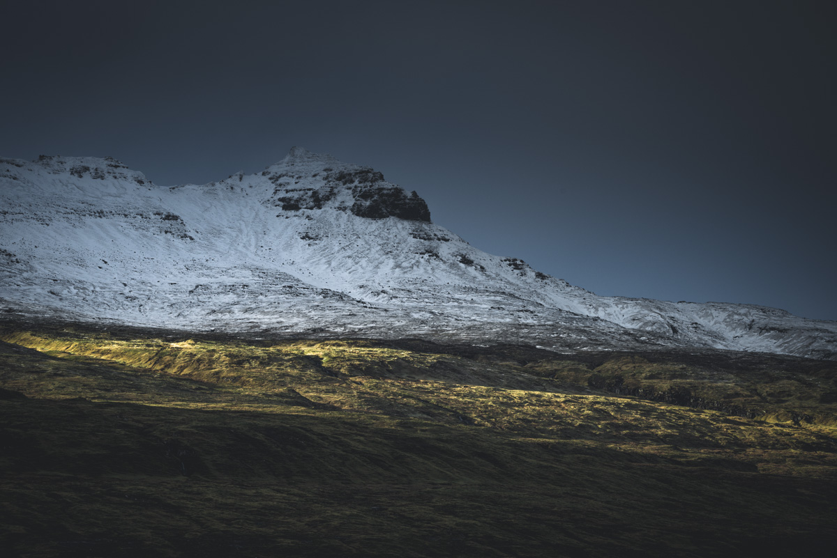 Färöer Inseln, Schneebedeckter Gipfel mit goldenem Lichtband im Winterdunkel, Dramatische Berglandschaft - Bergfotografie