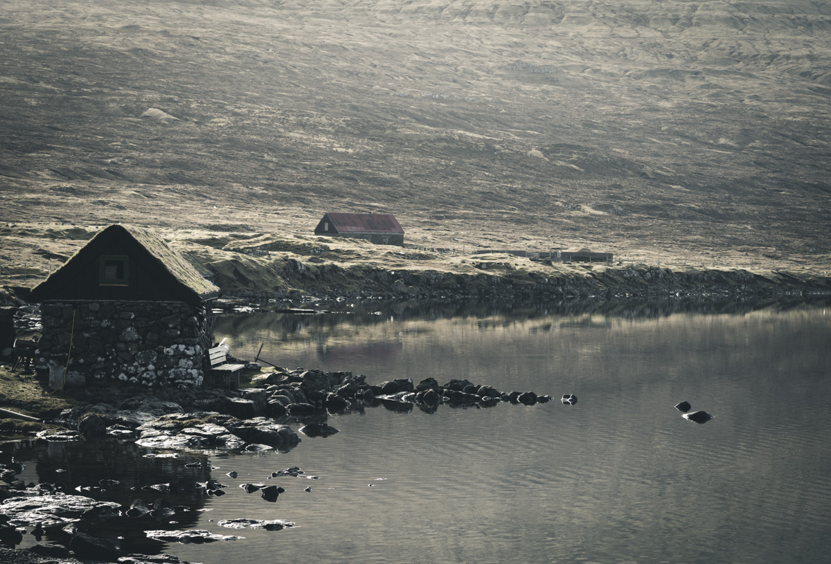 Färöer Siedlung, Kleine Steinhäuser am Fjordufer vor kargem Berghang, Nostalgisch - Landschaftsfotografie Nordatlantik