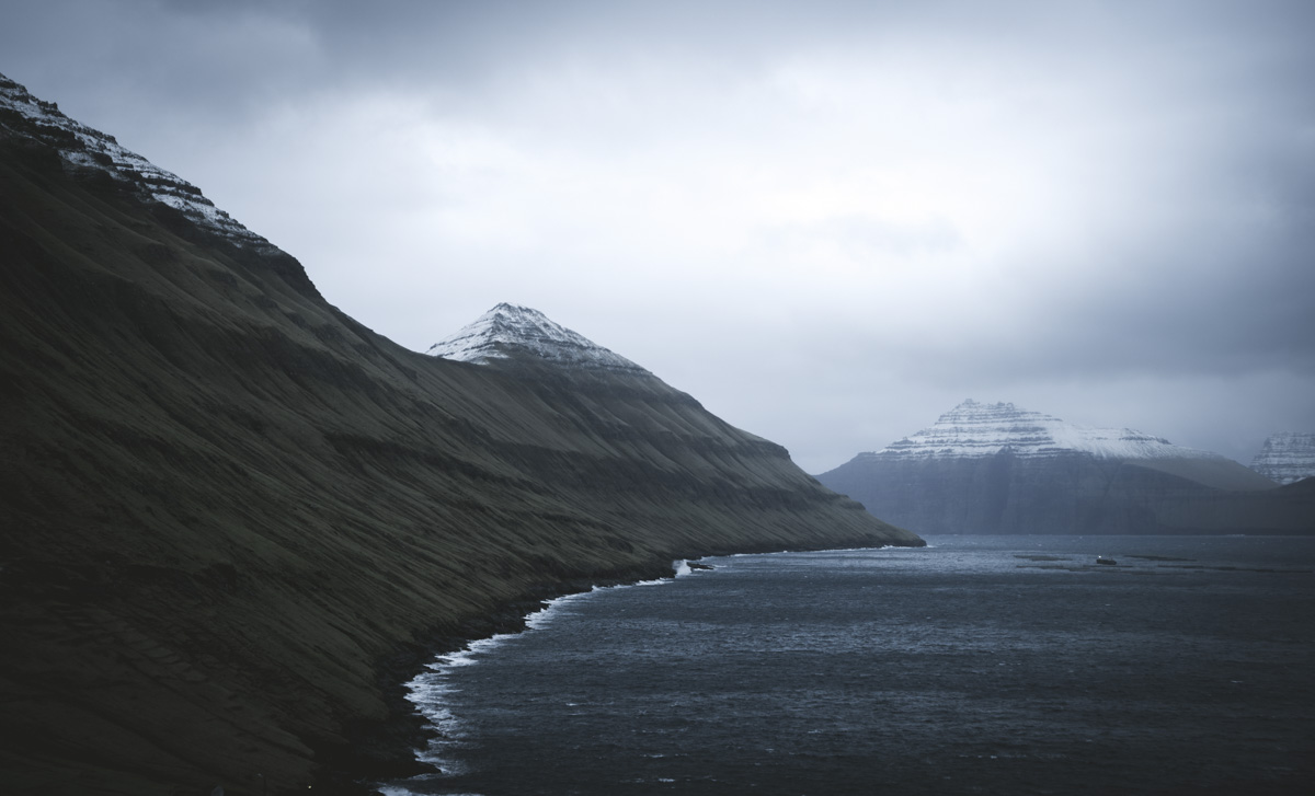 Färöer Steilküste, Schneebedeckte Pyramidenberge über Fjord mit Brandungslinie, Imposant - Landschaftsfotografie Nordatlantik