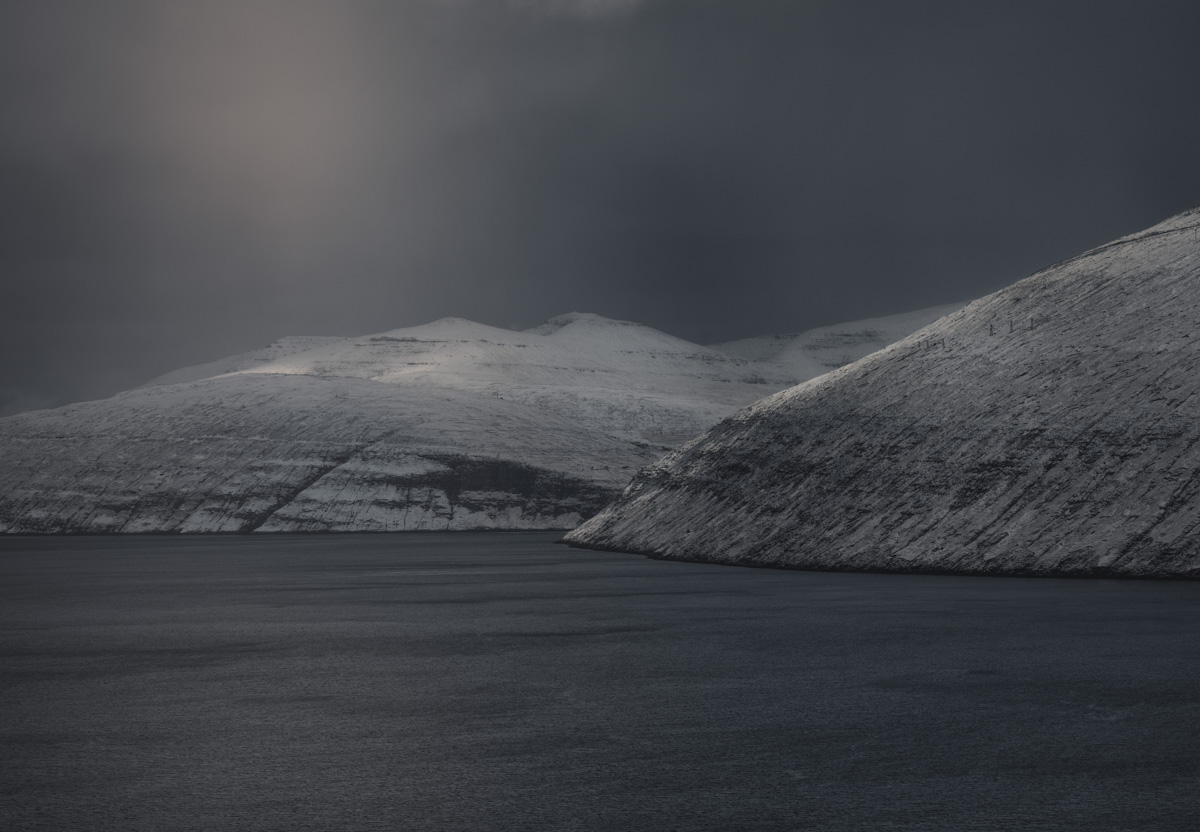 Färöer, Verschneite Berge über silbrigem Fjord, Monochrome Winterstille - Landschaftsfotografie Nordatlantik