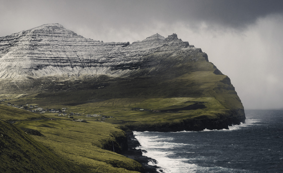 Färöer, Imposanter Schichtberg über grünem Dorf an der Steilküste, Monumentale Berglandschaft - Landschaftsfotografie
