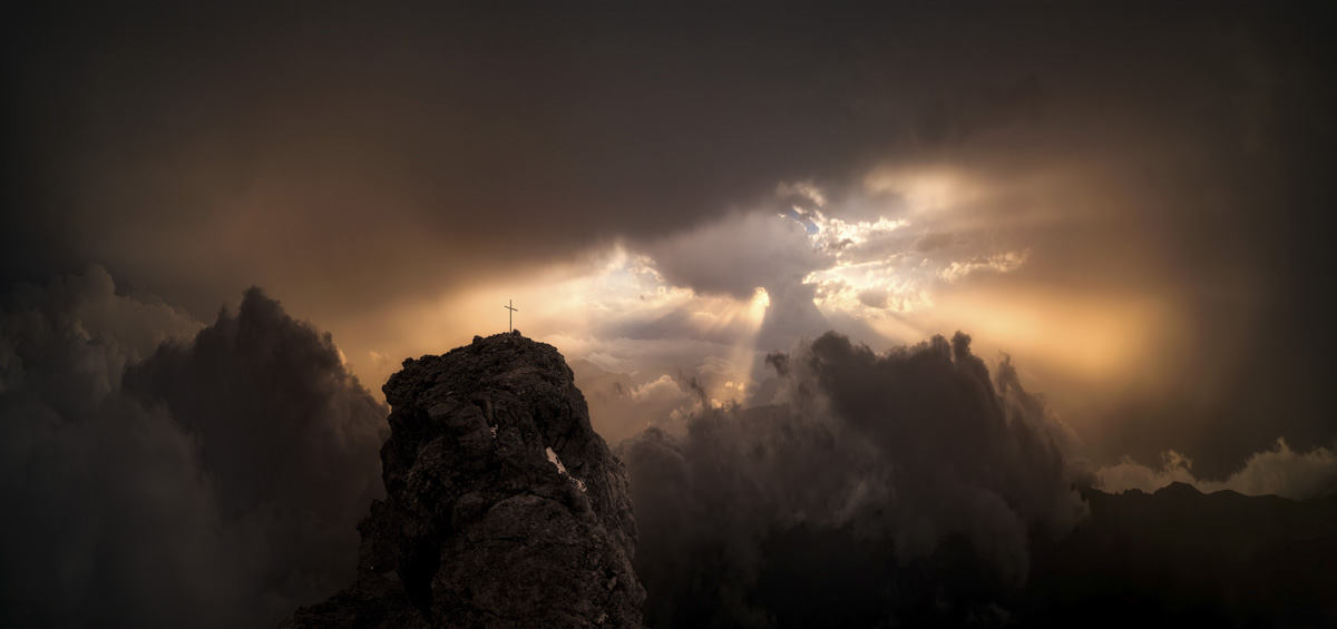 Gipfelkreuz im Gewitter bei Oberstdorf, Sonnenstrahlen durch dramatische Wolken, Mystische Bergfotografie Allgäu