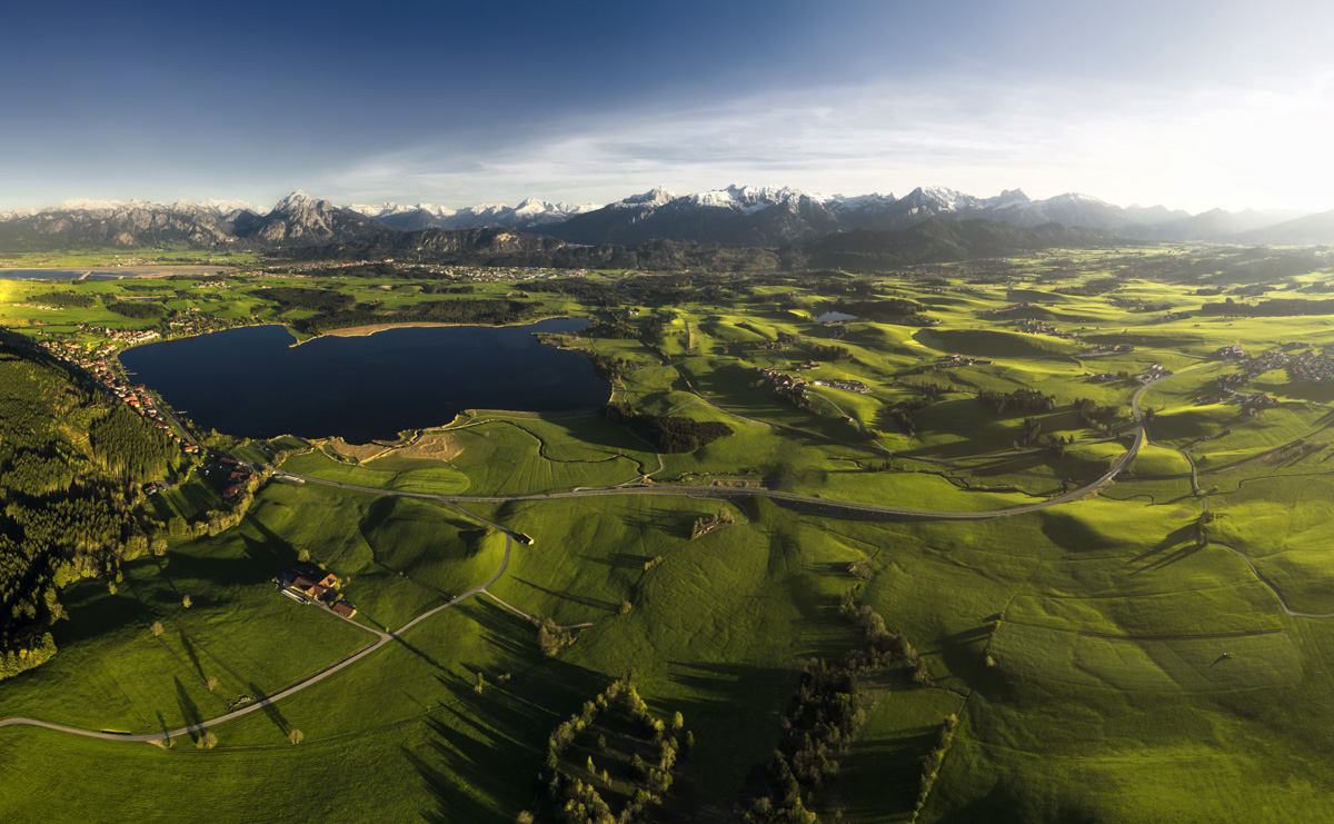 Hopfensee und Forggensee im Frühlingslicht, Grüne Hügellandschaft im Ostallgäu mit Alpenpanorama, Luftbildfotografie Bayern
