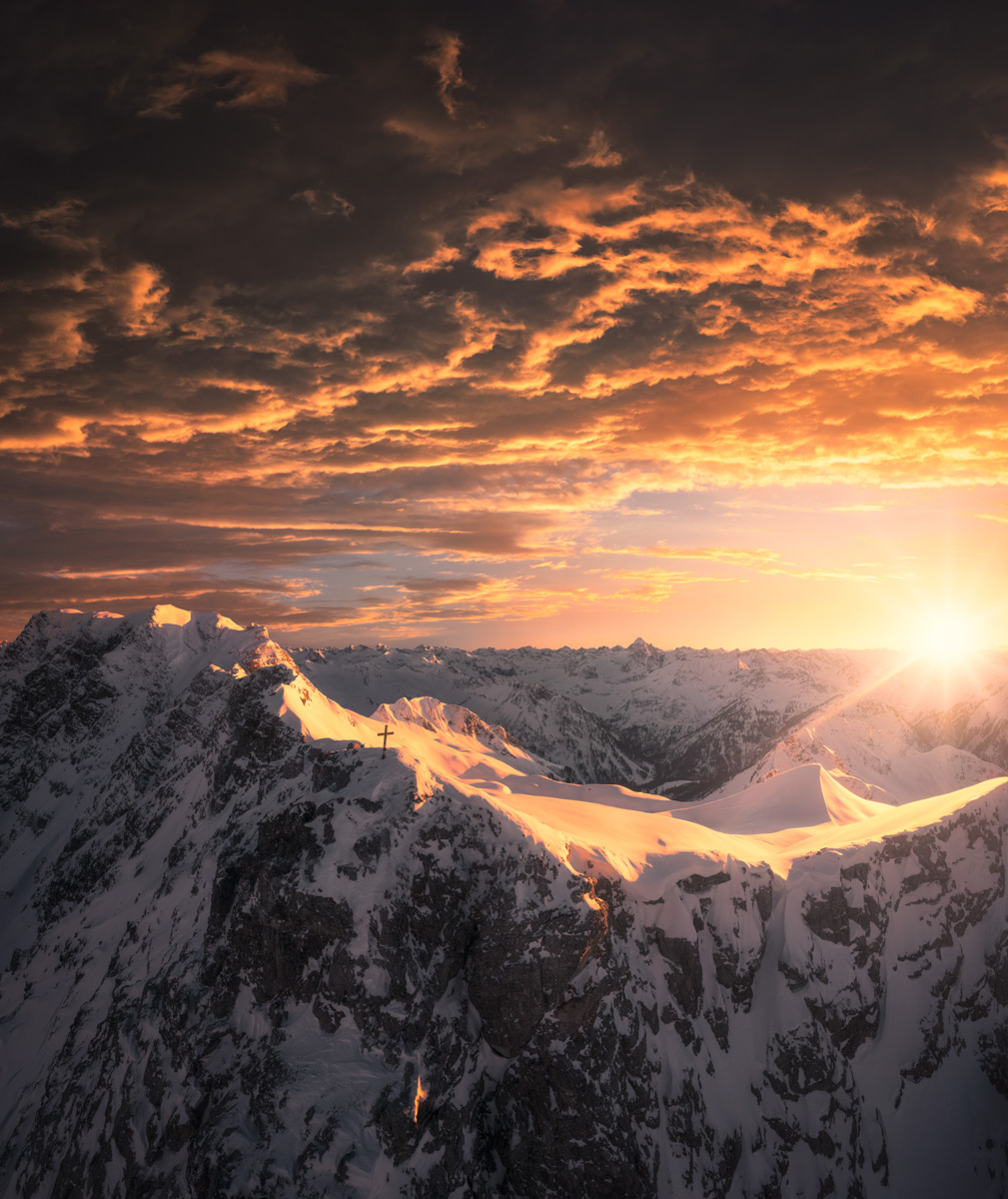 Hintersteiner Gipfelgrat im Sonnenuntergang, Dramatisches Winterlicht über verschneiten Allgäuer Hochalpen mit Gipfelkreuz