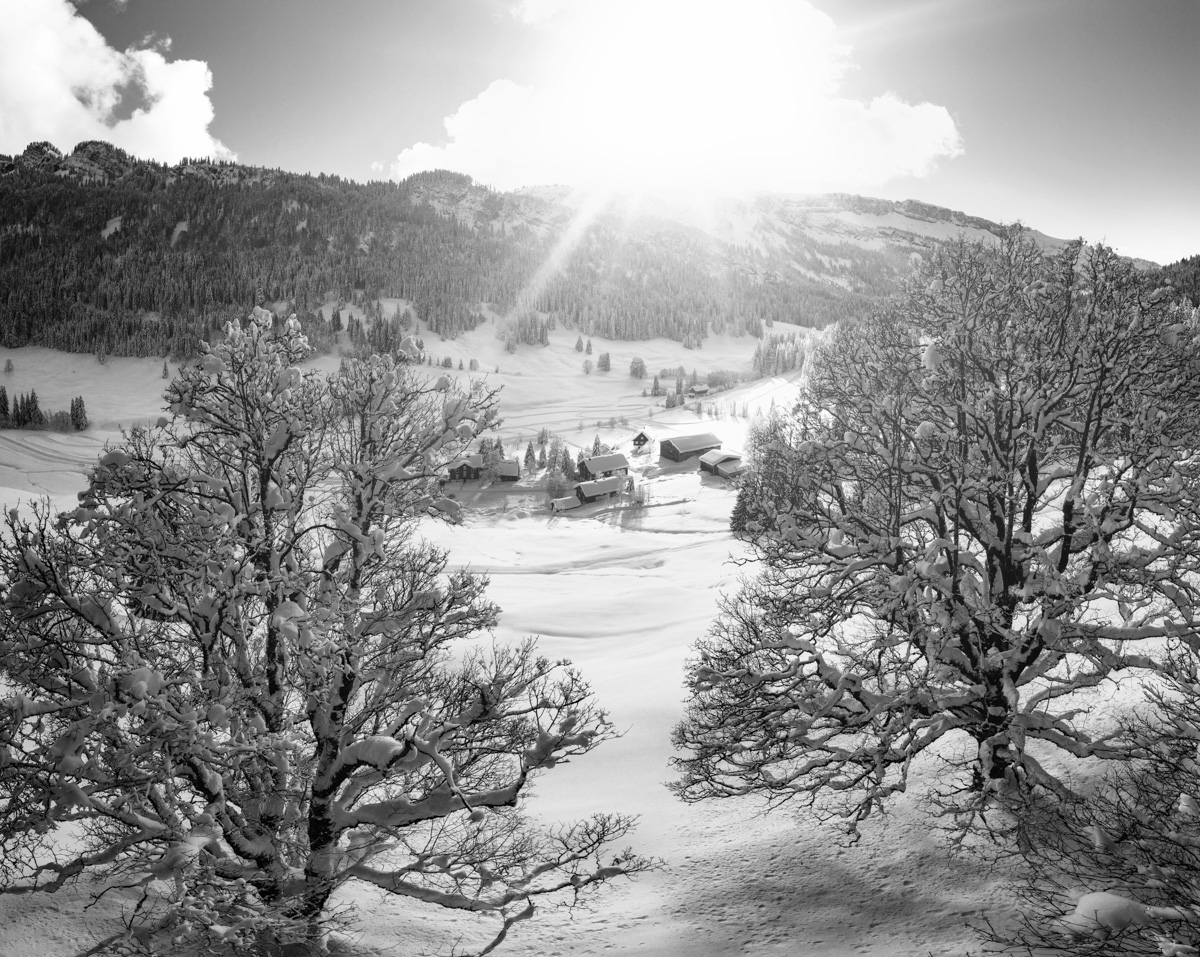 Rohrmoos im verschneiten Wintertal, Schwarz-Weiß Panorama mit kahlen Bäumen und Bauernhof bei Tiefenbach Oberstdorf