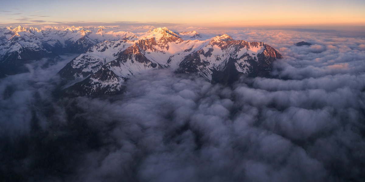 Allgäuer Gipfel über dem Wolkenmeer bei Sonnenuntergang, Verschneite Berge im rosafarbenen Abendlicht, Hinterstein