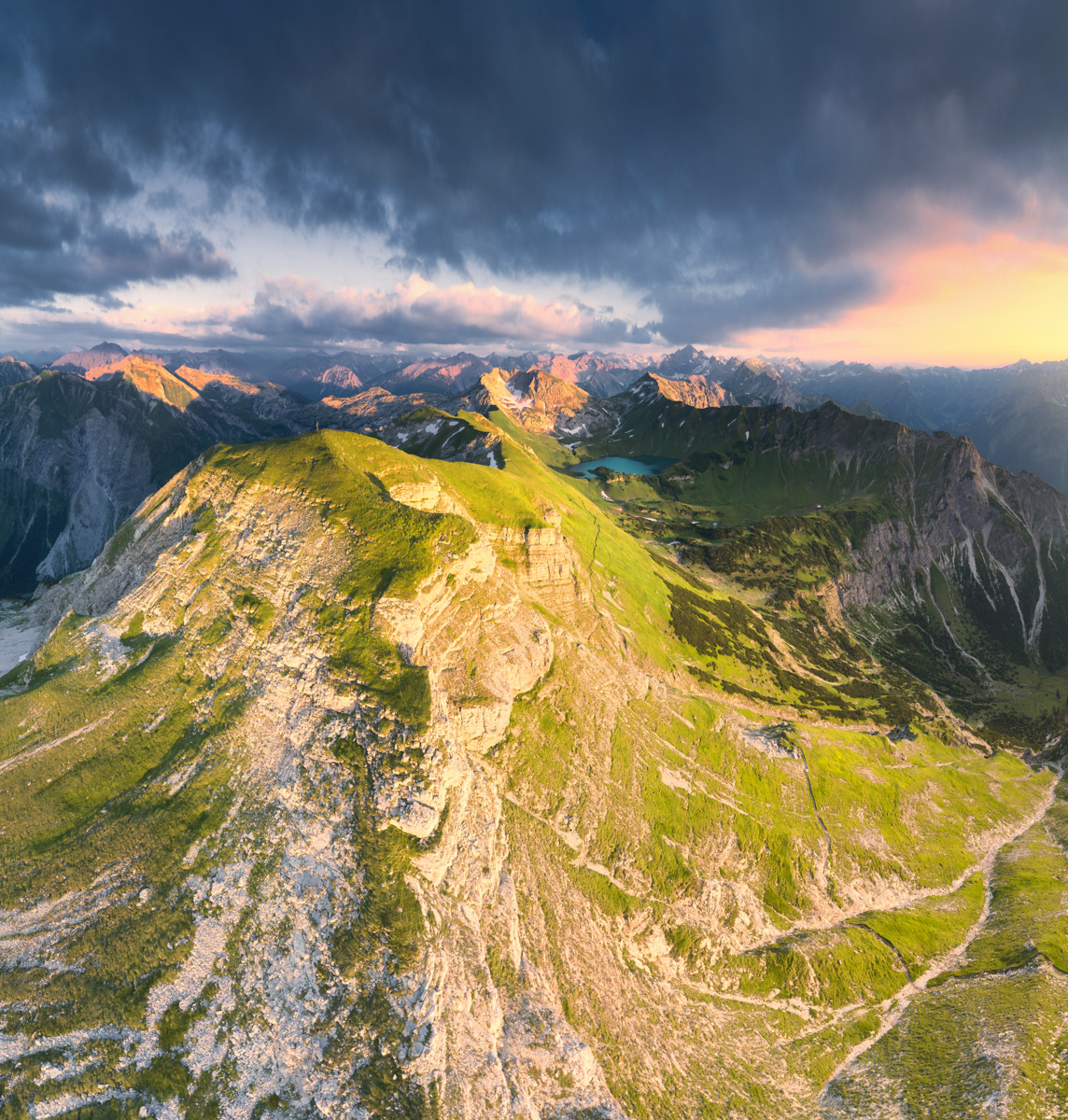 Schrecksee bei Sonnenuntergang aus der Luft, Türkiser Bergsee und grüner Gipfelgrat im goldenen Licht, Hinterstein