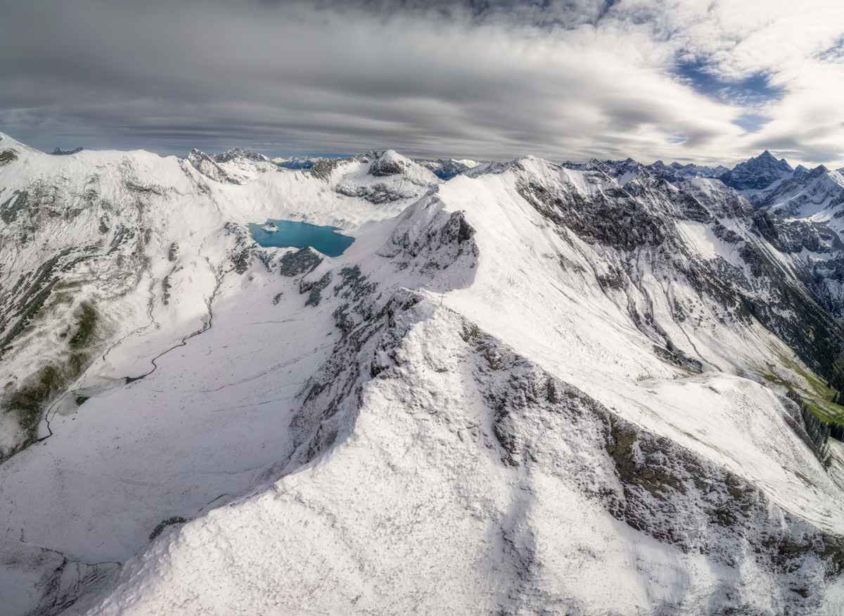 Schrecksee im ersten Schnee, Türkiser Bergsee zwischen verschneiten Gipfeln, Winterbeginn bei Hinterstein