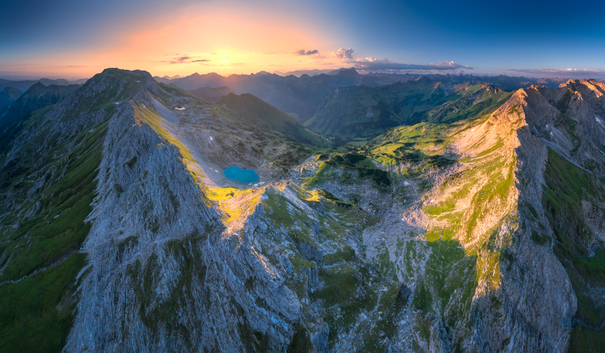 Laufbichelsee bei Sonnenaufgang, Türkiser Bergsee zwischen schroffen Gipfeln, Sommerliches Morgenlicht bei Hinterstein