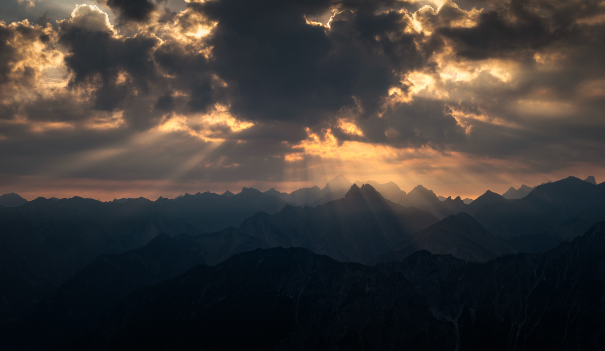 Allgäuer Bergsilhouetten, Sonnenstrahlen durch dramatische Wolken über Oberstdorf, Gestaffelte Gipfelketten im Gegenlicht